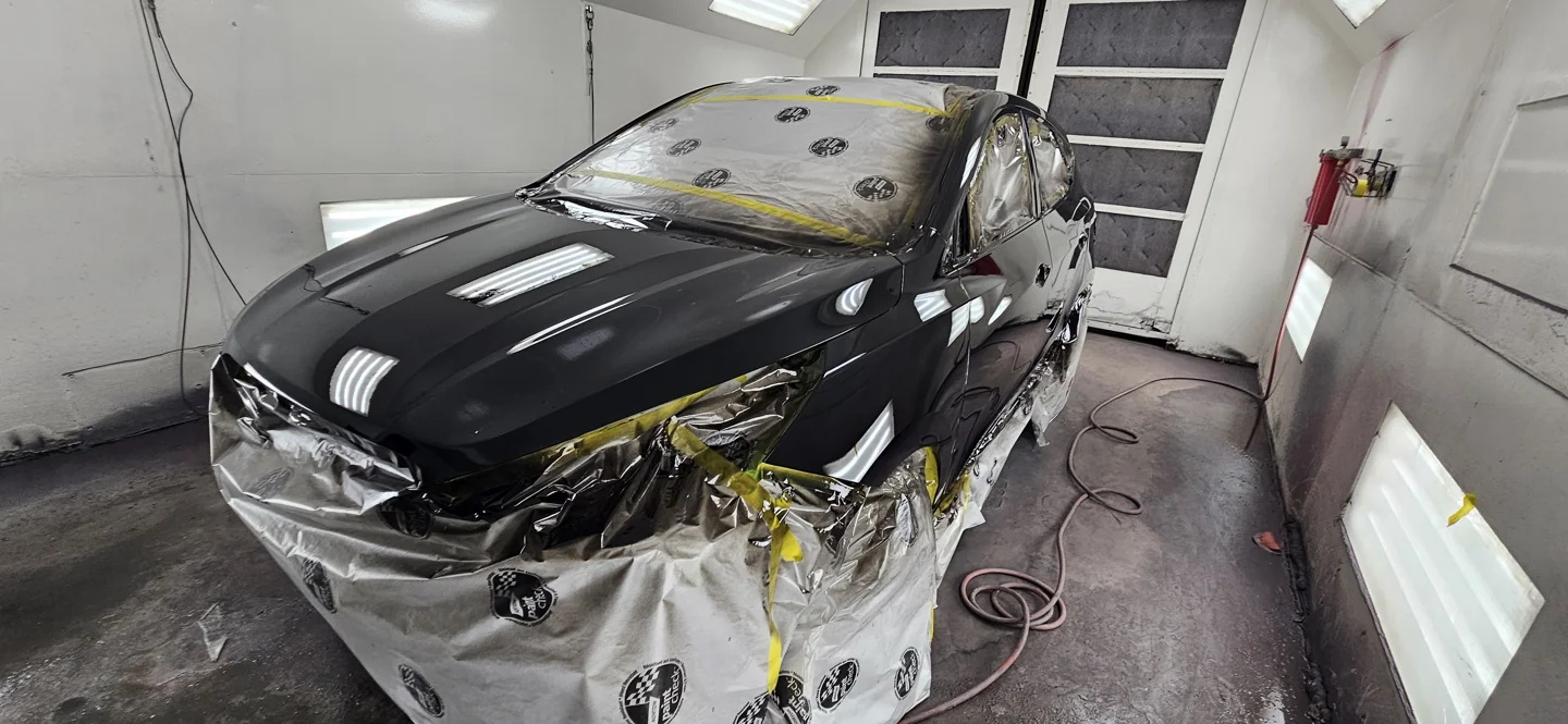 Vehicle masked for painting in the repair bay